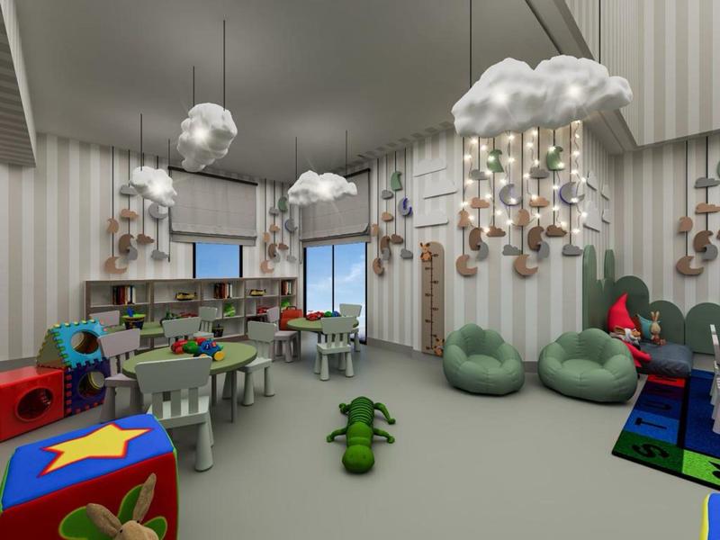 Sala giochi per bambini con mobili colorati, lampade a forma di nuvola e puff in un hotel.