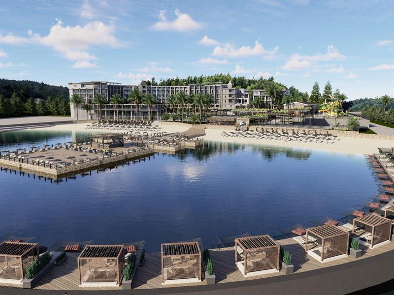 Complesso alberghiero moderno con lago, aree relax sull'acqua e paesaggio verde sullo sfondo.