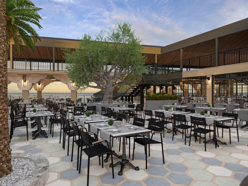 Accogliente area esterna dell'hotel con sedie e tavoli neri all'aperto.