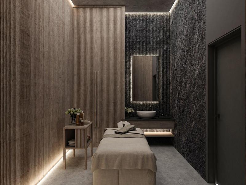 Stanza spa moderna con lettino da massaggio, refrigeratore per vino e illuminazione indiretta