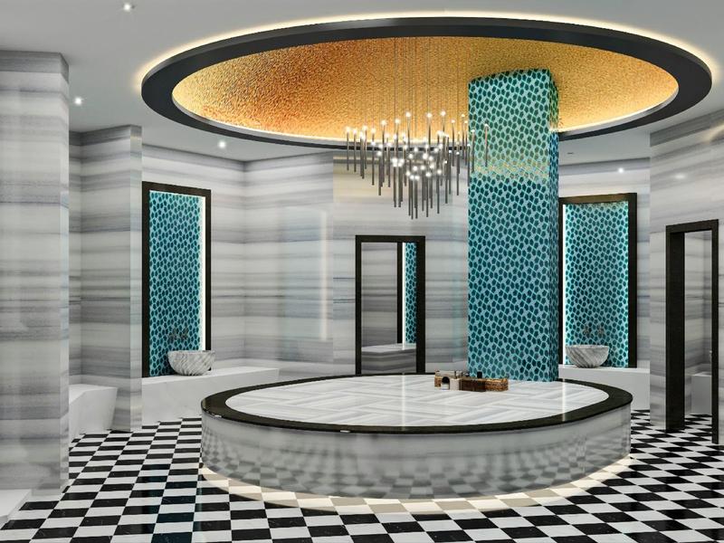 Area spa moderna con vasca idromassaggio, pareti in marmo, colonne e lampadario.