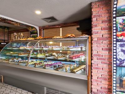 Modern pastry shop with a large display case filled with various cakes and pastries.