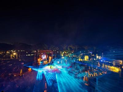 Night beach party with colorful lights and people enjoying themselves