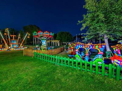 Illuminated playground with children's carousel and rides outdoors at night