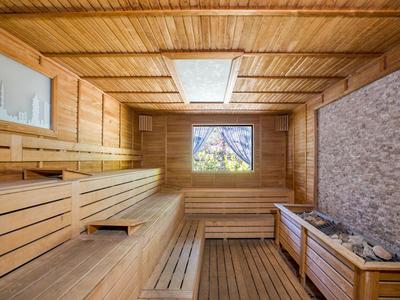 Cozy sauna with wooden paneling and window with an outdoor view.