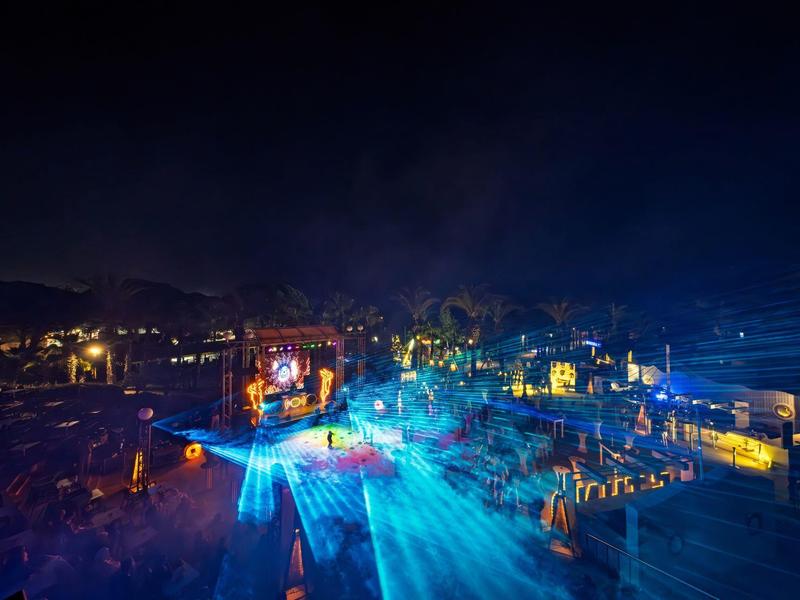 Night beach party with colorful lights and people enjoying themselves
