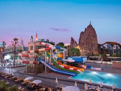 Parc aquatique coloré avec toboggans et piscine au coucher du soleil