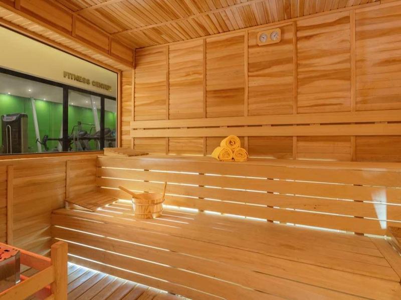 Jasne i przytulne wnętrze drewnianej sauny z ławkami i gorącymi kamieniami.