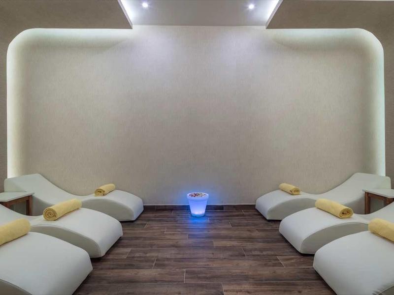 Nowoczesna sala relaksu z białymi fotelami i miękkim oświetleniem.