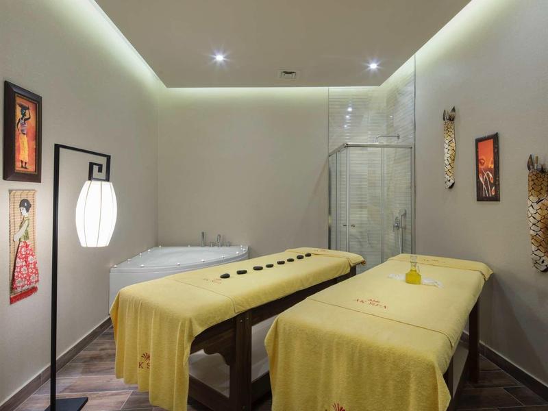 Pokój spa z dwoma stołami do masażu i miękkim oświetleniem, relaksująca atmosfera.