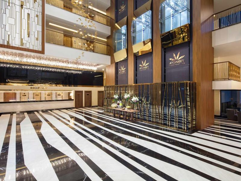 Luksusowy hol hotelowy z czarno-białą podłogą w paski i nowoczesnym oświetleniem.