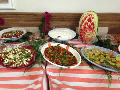 Bufet s různými saláty a umělecky vyřezaným vodním melounem jako dekorací.