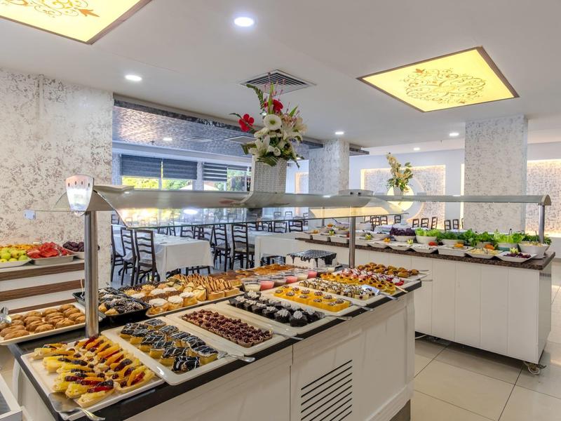 Buffet moderno en un comedor luminoso con varias bandejas de comida y mostradores.