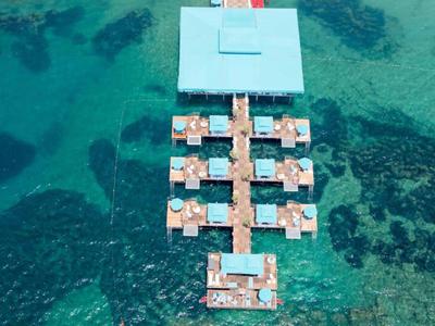 Bungalow sull'acqua con passerelle in legno in acqua turchese limpida