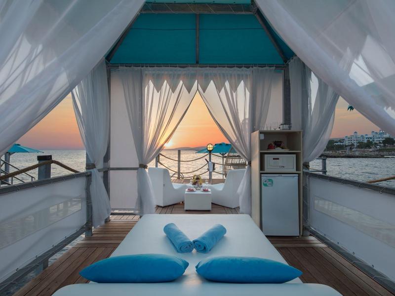 Área de masaje al aire libre con vista al atardecer y al mar en la playa del hotel.