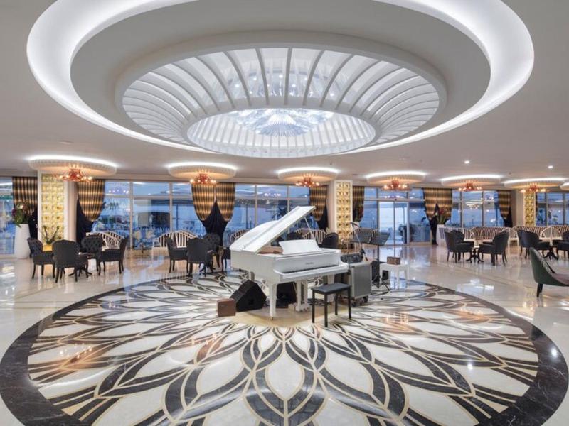 Salón elegante con piano de cola blanco y patrón decorativo en el suelo, iluminado con estilo.