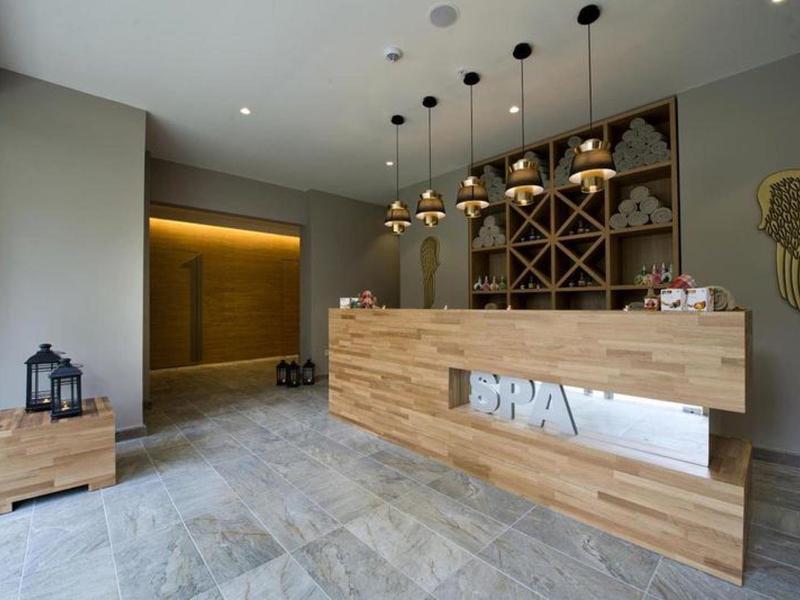 Moderner Empfangsbereich mit Holztheke, Weinregal und gedämpfter Beleuchtung.