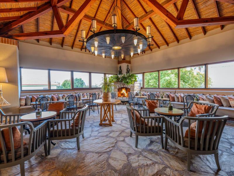 Gemütlicher Lounge-Bereich mit Steindach, Kamin und Panoramafenstern in einem Hotel.