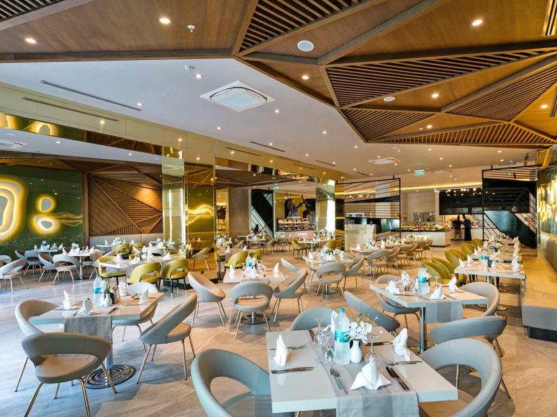 Modern hotelrestaurant met stijlvolle tafels en comfortabele stoelen in een warme sfeer.