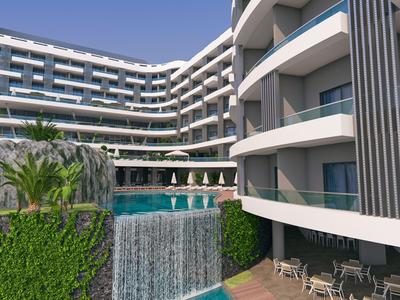 Modern hotel met buitenzwembad, waterval en terras met tafels en stoelen.