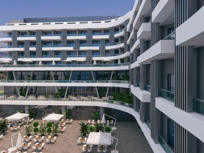 Modern hotelcomplex met grote balkons en een lager gelegen gebied met tafels en parasols.