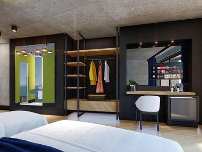 Moderne hotelkamer met bed, kast, bureau en grote spiegel in neutrale tinten.