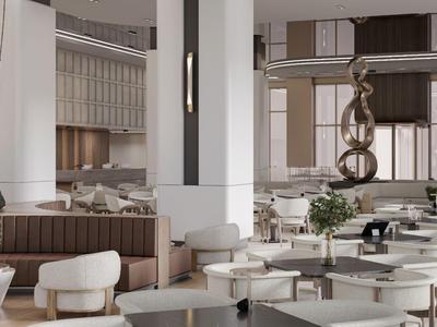 Area lounge moderna di un hotel con sedie bianche, tavoli lunghi e grande scultura astratta.