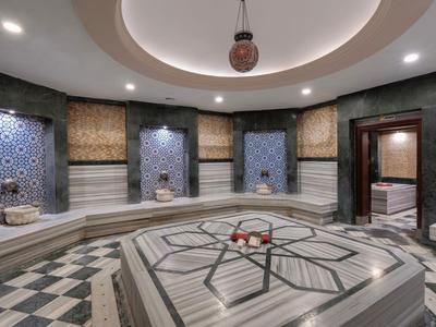 Eleganter Hammam mit marmornen Sitzflächen, geometrischen Mustern und warmem Licht.