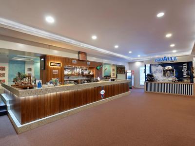 Moderner Hotelbarbereich mit Holztheke, Beleuchtung und separater Eiskreamstation.