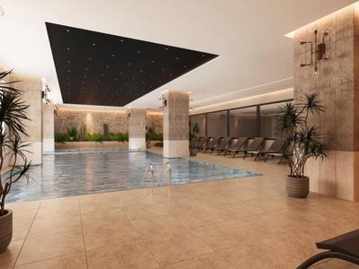 Modernes Indoor-Schwimmbad mit Pflanzen, Liegestühlen und stilvoller Beleuchtung.