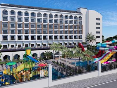 Großes Hotel mit Außenpoolbereich und bunten Wasserrutschen vor blauem Himmel