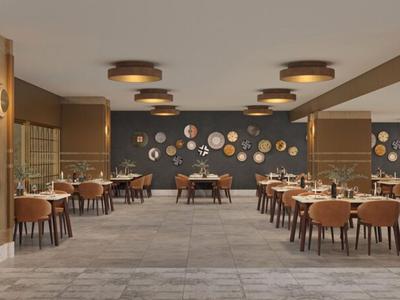 Moderner Frühstücksraum mit vielen Tischen und Stühlen, warmes Farbkonzept und dekorative Wanduhren