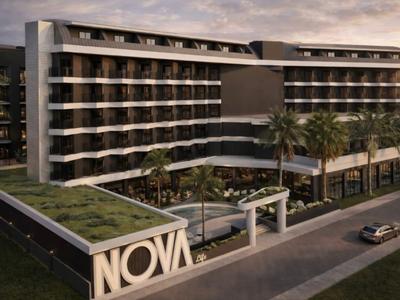 Hotel moderno con più piani, grande piscina e palme al tramonto.