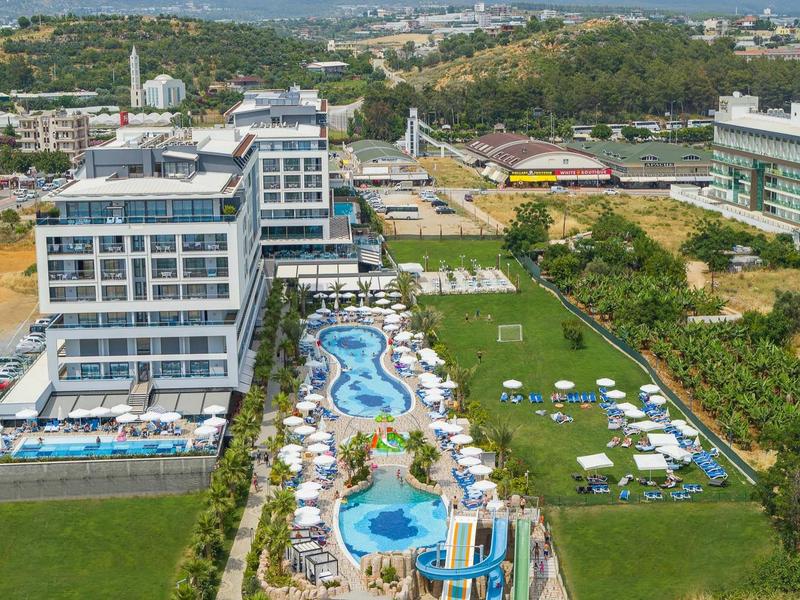 Complexe hôtelier moderne avec plusieurs piscines, transats et espaces verts