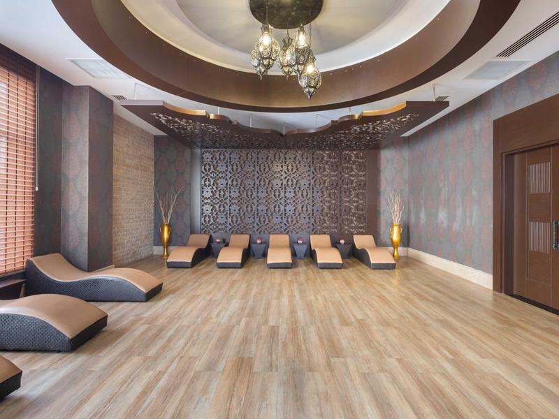 Sala de descanso moderna con cómodas tumbonas, revestimiento de madera y luz decorativa en el hotel.