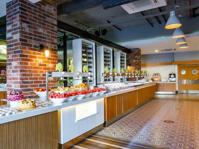 Große Buffetauswahl mit frischem Obst, Shakes und dekorativen Wänden in modernem Speiseraum.
