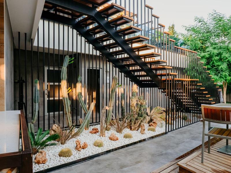 Modern stairway with wooden steps and indoor garden in a hotel lobby area.