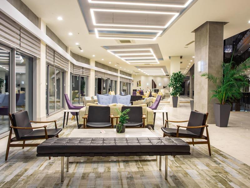 Modern hotel outdoor area with seating and covered terrace at night.