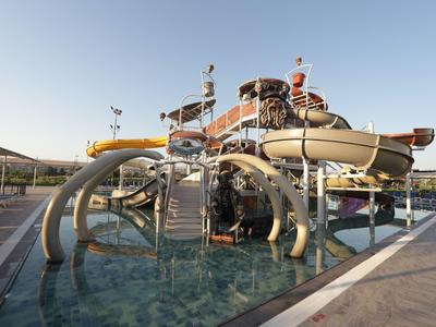 Vodní dráha s tobogány a strukturami v venkovním bazénu za jasného nebe.