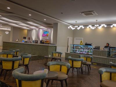 Elegantní salonek se žlutými křesly v moderním a světlém hotelu.