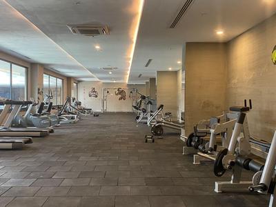 Ein moderner, heller Fitnessraum mit Laufbändern, Fahrrädern und Kraftgeräten.