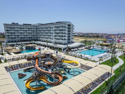 Moderní hotelový komplex s bazény, vodními skluzavkami a odpočinkovými zónami na slunci.