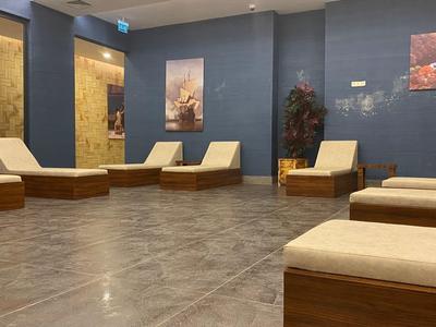 Relax místnost s dřevěnými lehátky a modrými stěnami.