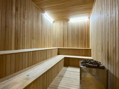 Interiér sauny ze dřevěnými lavicemi a topidlem.