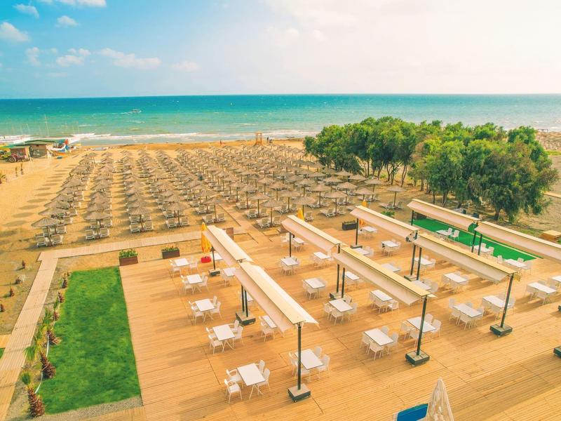 Dobře uspořádaná pláž s slunečníky a venkovní restaurací u moře.