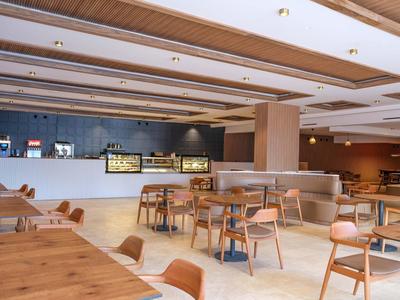 Světla, moderní restaurace s dřevěným nábytkem a barem v otevřeném prostoru.