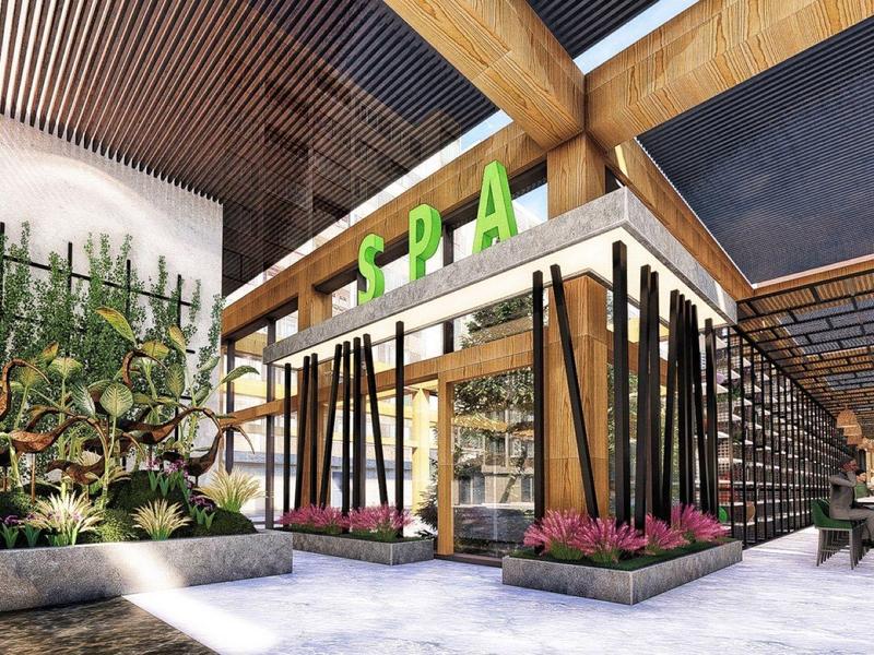 Moderne spa-entree met grote glazen wanden, houten balken en hoge planten in een gezellige omgeving.