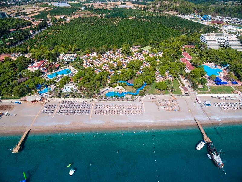 Letecký pohled na plážový resort s lehátky, bazény a přilehlým mořem