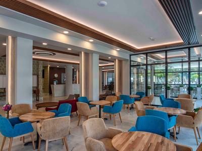 Gezellige hotel-lounges met blauwe en beige stoelen en moderne houten tafels.