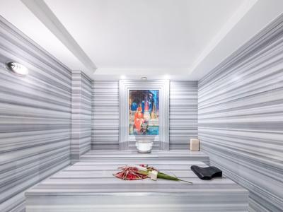 Moderne kamer met gestreepte muren, centrale zitplaats en een schilderij aan de muur.